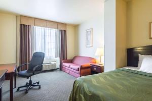 a hotel room with a bed and a desk and a chair at Quality Inn and Suites Alma in Alma