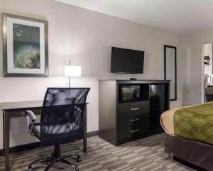 a hotel room with a bed and a desk and a television at HomeStay Inn & Suites in Russellville