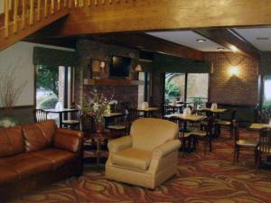 un restaurante con sofá, mesas y sillas en Quality Inn & Suites Searcy I-67 en Searcy