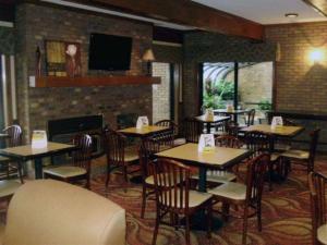 un restaurant avec des tables, des chaises et une cheminée dans l'établissement Quality Inn & Suites Searcy I-67, à Searcy