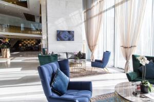 a lobby with blue chairs and a table at Swissotel Sarajevo in Sarajevo