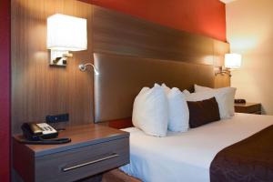 um quarto de hotel com uma cama e um telefone em American Inn & Suites West Memphis em West Memphis
