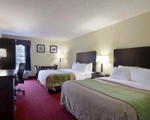 a hotel room with two beds and a desk at Quality Inn & Suites Little Rock West in Little Rock