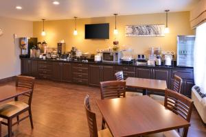 a restaurant with tables and a counter with a kitchen at Sleep Inn Fayetteville North in Fayetteville