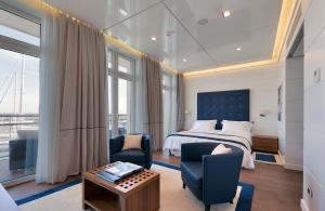 een slaapkamer met een bed, een stoel en een tafel bij Yacht Club Marina Di Loano in Loano