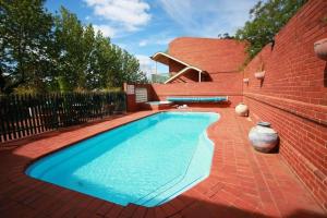 uma piscina ao lado de uma parede de tijolos em Comfort Inn Lady Augusta em Swan Hill