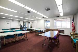 une salle de classe avec des tables et des chaises et un drapeau américain dans l'établissement Rodeway Inn Kingman Route 66, à Kingman