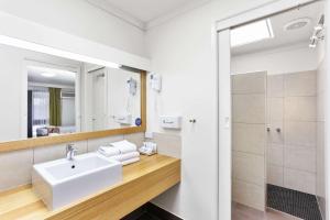 a bathroom with two sinks and a mirror at Comfort Inn Botanical in Hamilton