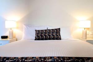 a white bed with a white comforter and pillows at Comfort Inn Benalla in Benalla