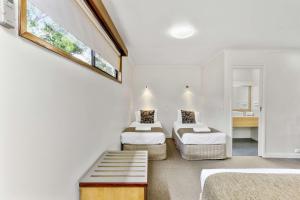 Zimmer mit 2 Betten und einer Bank in der Unterkunft Botanical Hamilton in Hamilton