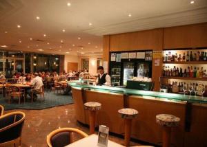 a restaurant with a bar and people sitting at tables at The Oxley Motel Dubbo in Dubbo