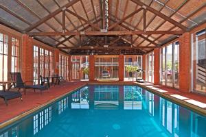 a swimming pool in a house with a large ceiling at Main Lead Ballarat Motel in Ballarat