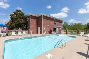 a large swimming pool with chairs and a brick building at Quality Inn & Suites Mountain Home North in Mountain Home