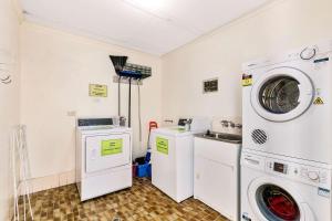 - une buanderie avec deux machines et un lave-linge/sèche-linge dans l'établissement Comfort Inn on Main Hervey Bay, à Hervey Bay