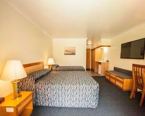 
a hotel room with two beds and a television at Comfort Inn Bay of Isles in Esperance
