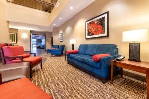 uma sala de estar com um sofá azul e cadeiras em Comfort Suites Goodyear-West Phoenix em Goodyear