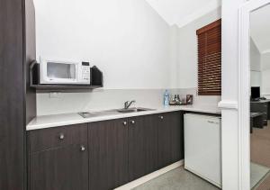 a kitchen with a microwave and a sink at Comfort Inn & Apartments Northgate Airport Motel in Brisbane