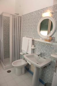 a bathroom with a sink and a toilet and a mirror at Hotel Venere in Ascea