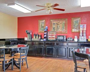 a restaurant with red walls and tables and chairs at Econo Lodge Pine Bluff in Pine Bluff