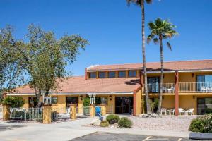 a building with a palm tree in front of it at Quality Inn Wickenburg in Wickenburg