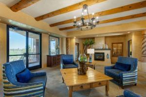 a living room with blue chairs and a wooden table at La Posada Lodge & Casitas, Ascend Hotel Collection in Tucson