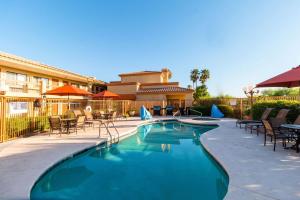 a swimming pool in front of a building with tables and chairs at Quality Inn Casa Grande I-10 in Casa Grande