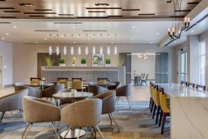 um restaurante com mesas e cadeiras e um bar em Cambria Hotel Phoenix Chandler - Fashion Center em Chandler