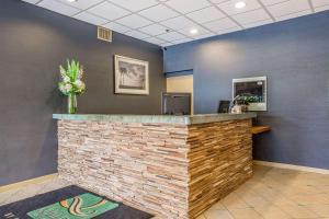 a lobby with a brick counter and blue walls at Quality Inn & Suites Hermosa Beach in Hermosa Beach