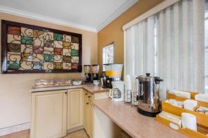 a kitchen with a counter with a coffee maker on it at Rodeway Inn Escondido Downtown in Escondido