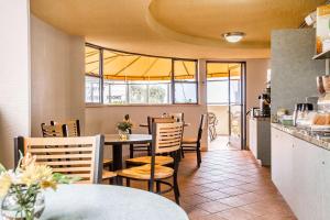 ein Restaurant mit einem Tisch und Stühlen sowie einer Küche in der Unterkunft Quality Inn & Suites Hermosa Beach in Hermosa Beach