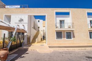 a facade of a building with a patio and stairs at Hotel Paladini di Francia in Lampedusa