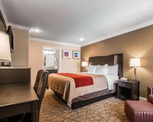a hotel room with a bed and a desk at Quality Inn Downey in Downey +24 photos