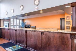 a large bar with wooden cabinets in a room at Quality Inn & Suites Bell Gardens-Los Angeles in Bell Gardens