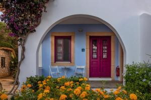 una casa azul y blanca con una puerta roja en Nefeli Hotel Leros, en Agia Marina