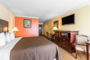 a hotel room with a bed and a flat screen tv at Quality Inn & Suites Bell Gardens-Los Angeles in Bell Gardens