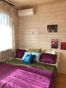 a bed in a room with purple and green pillows at Добрый Лев in Sukhum