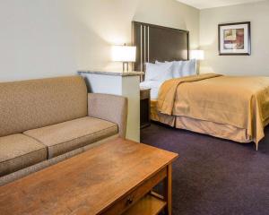 une chambre d'hôtel avec un lit et un canapé dans l'établissement Quality Inn & Suites Woodland - Sacramento Airport, à Woodland