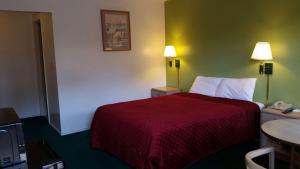 Habitación de hotel con cama con colcha roja en Rodeway Inn Civic Center, en San Francisco