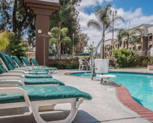a row of chaise lounge chairs next to a swimming pool at Quality Inn Temecula Valley Wine Country in Temecula