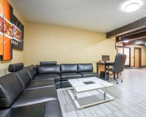 a living room with a leather couch and a table at Quality Inn near Mammoth Mountain Ski Resort in Mammoth Lakes