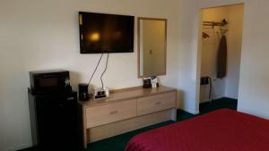 a bedroom with a dresser with a television on the wall at Rodeway Inn Civic Center in San Francisco