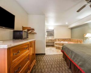 een hotelkamer met een bed en een televisie bij Rodeway Inn Delano in Delano