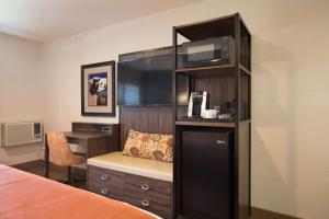 Zimmer mit einem Bett, einem Schreibtisch und einer Mikrowelle in der Unterkunft The Vine Inn Davis in Davis