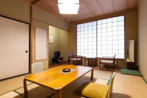 a room with a table and chairs and a large window at Hotel Seikoen in Nikko