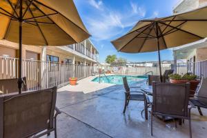 a patio with tables and umbrellas and a pool at Rodeway Inn Magic Mountain Area in Castaic