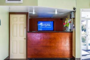 ヘイワードにあるRodeway Inn & Suitesの壁にテレビとドアが付いた部屋