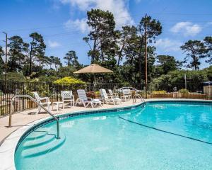 a swimming pool with chairs and an umbrella at The Inn at 1252 Monterey in Monterey