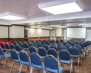 une salle de conférence avec des chaises bleues et un écran blanc dans l'établissement Quality Inn Riverside near UCR and Downtown, à Riverside