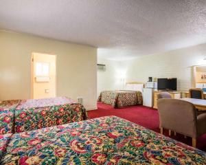 a hotel room with two beds and a desk at Jefferson Inn in Yreka