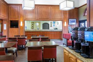 un restaurant avec des murs en bois, des tables et des chaises dans l'établissement Comfort Inn & Suites San Francisco Airport North, à South San Francisco